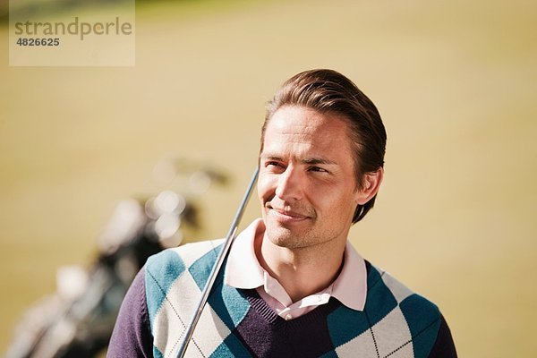 Italien  Kastelruth  Mittlerer Erwachsener Mann mit Golftasche auf dem Golfplatz