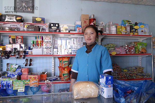 Verkäuferin vor den Waren des täglichen Bedarfs in einem kleinen Dorfladen in der Wüste Gobi  Gurvan Saikhan Nationalpark  Ömnögov Aimak  Mongolei  Asien