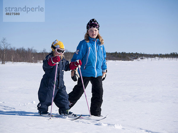 Zwei Schwestern  drei und acht Jahre  gehen im Schnee in Kiruna  Lappland  Nordschweden  Schweden  Europa