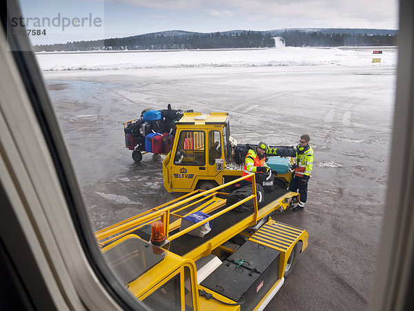 Auf dem Flughafen von Kiruna laden zwei Flughafen-Mitarbeiter die Koffer der Passagiere in ein Flugzeug  Lappland  Nordschweden  Schweden  Europa