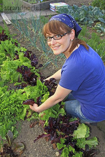 Junge Frau bei der Gartenarbeit in einem Bio-Hausgarten