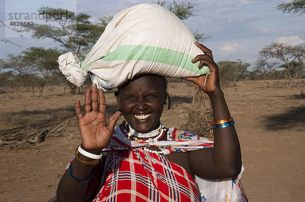 Massaifrau trägt einen Sack Mais auf dem Kopf zum Markt in Malambo  nördliches Tansania  Afrika