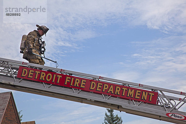 Ein Feuerwehrmann steigt die Leiter gestiegen  nachdem er ein Feuer gelöscht hat in einem der unzähligen Häuser an der East Side von Detroit die wegen Zwangsvollstreckung und der Rezession leer stehen  Detroit  Michigan  USA