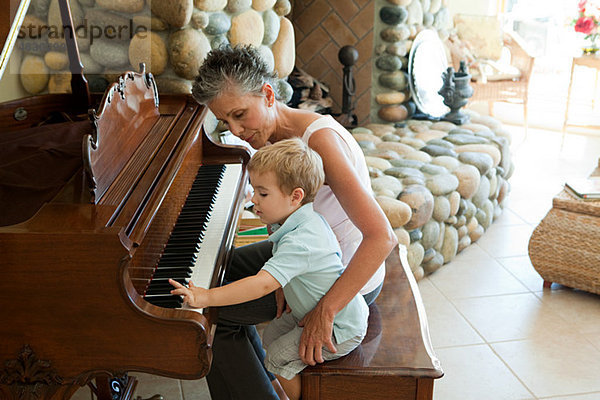 Großmutter und Enkel beim Klavierspielen