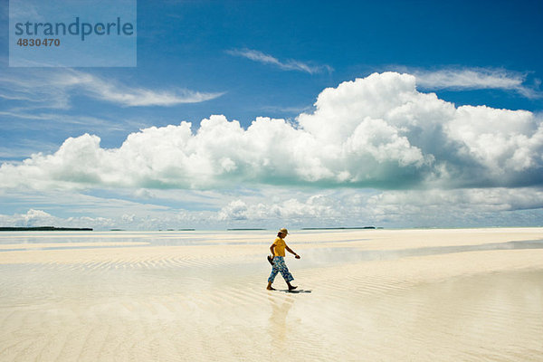 Mann geht am Strand entlang