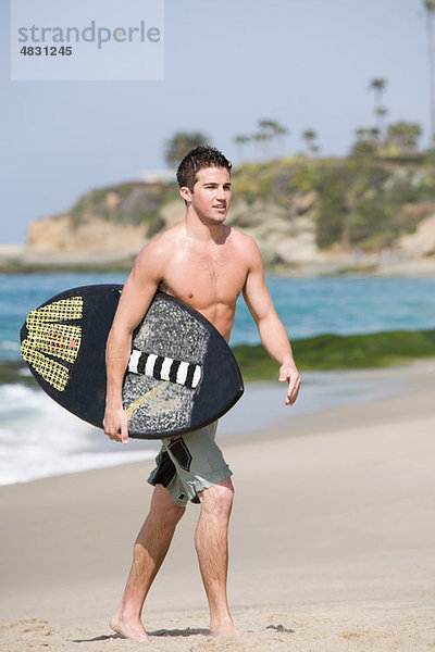Mann tragen Strand Surfboard jung