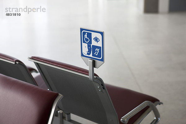 Schild im Wartebereich mit Sitzgelegenheiten für Behinderte