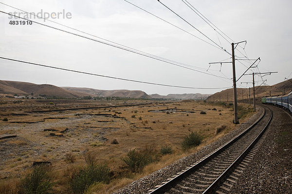 Usbekistan  Buchara  Eisenbahn und Stromleitungen durch karge Landschaft