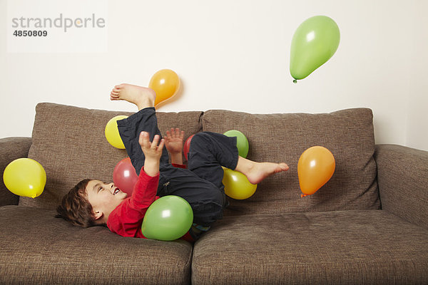 liegend  liegen  liegt  liegendes  liegender  liegende  daliegen  Couch  Junge - Person  Luftballon  Ballon  treten  jung