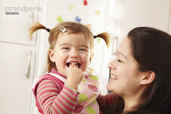 Mutter und Tochter lachen in der Küche