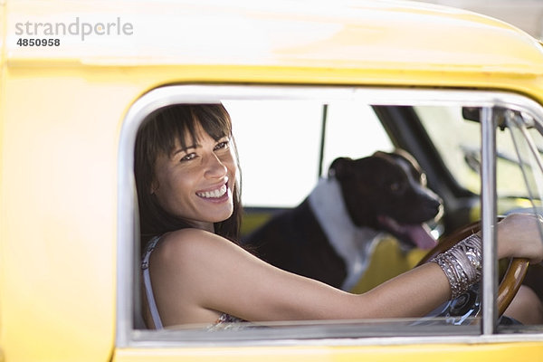 Mädchen mit Hund sitzend in gelbem Funcar