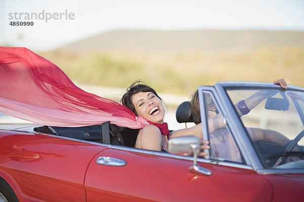 Frau mit langem roten Schal im Auto unterwegs