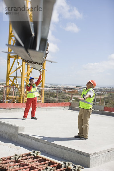 Kran und Arbeiter auf der Baustelle