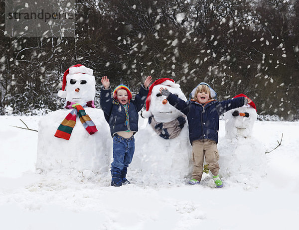 Zwei Jungen und ihre Schneemänner
