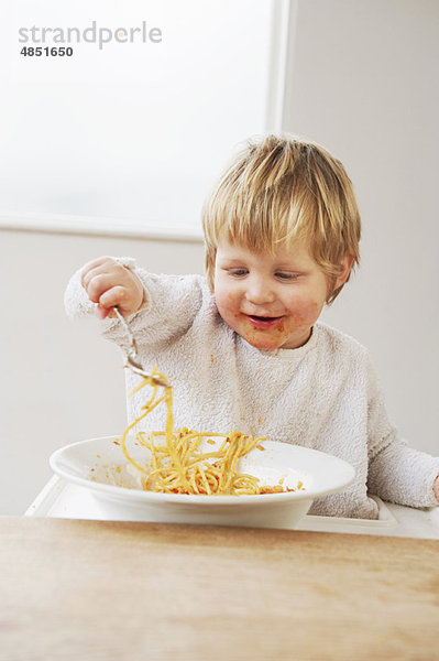 Glücklicher Junge  der Spaghetti isst.