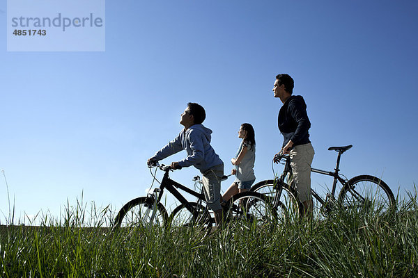 Familie mit Fahrrädern in der Sonne liegend