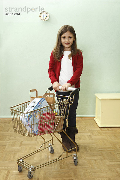 junges Mädchen mit Einkaufswagen