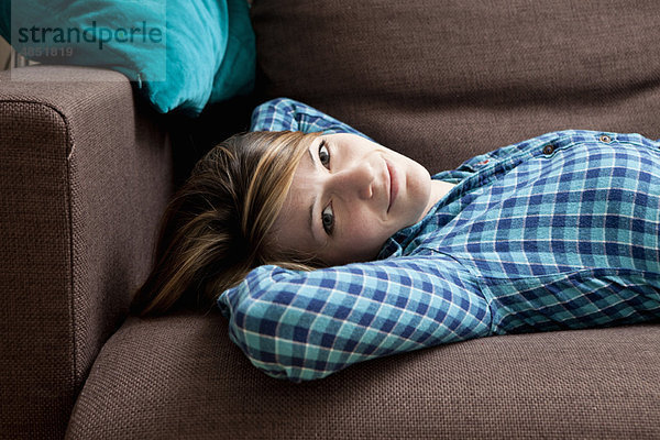 Porträt einer jungen Frau auf einem Sofa