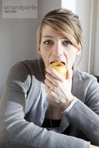 Junge Frau beim Essen eines Apfels