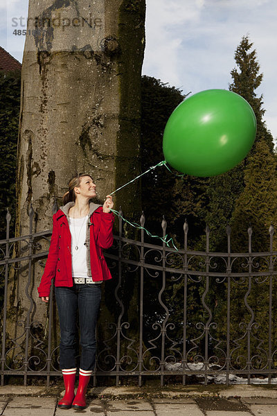 Frau mit grünem Ballon