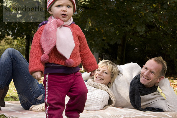 Familie mit einem Kleinkind entspannt im Park