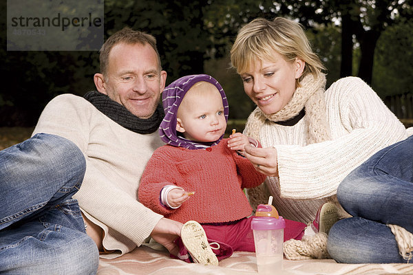 Familie mit einem Kleinkind entspannt im Park