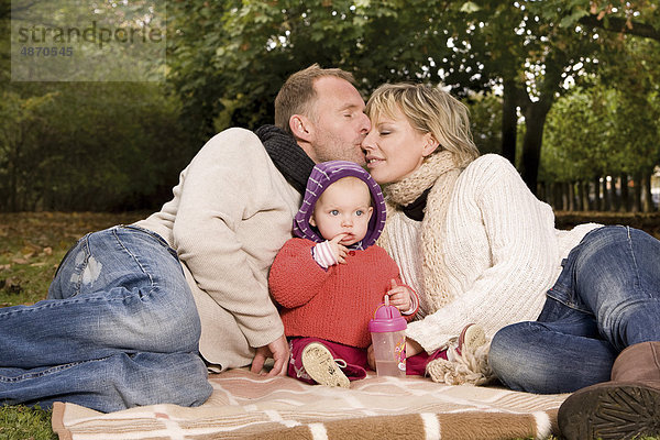 Familie mit einem Kleinkind entspannt im Park