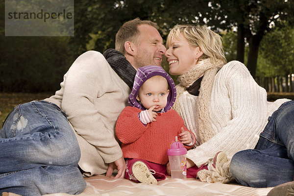 Familie mit einem Kleinkind entspannt im Park