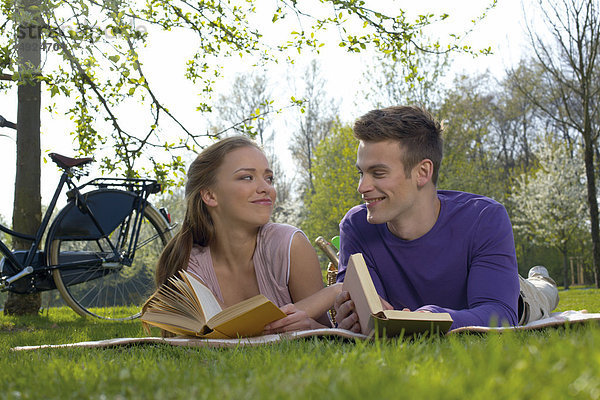Junges Paar liest auf einer Wiese