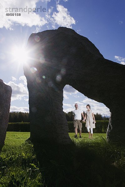 Paar zu Fuß in der Nähe von Denkmal im Feld