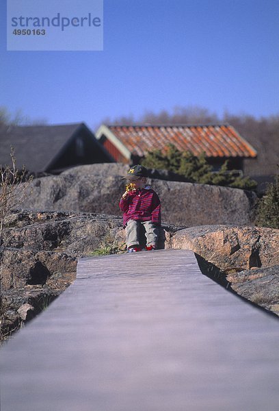 Junge sitzt auf jetty