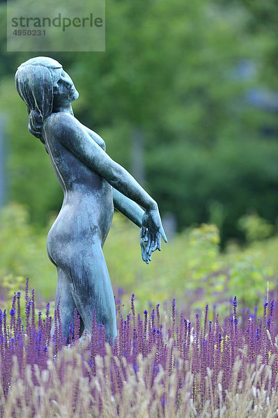 Statue von Frau in Blumenbeet