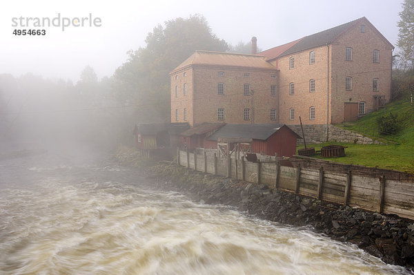 Backstein Gebäude am Ufer bedeckt mit Morgennebel