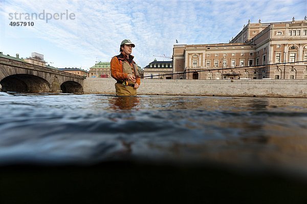 Mann Fliegenfischen in River in der Nähe der Altstadt