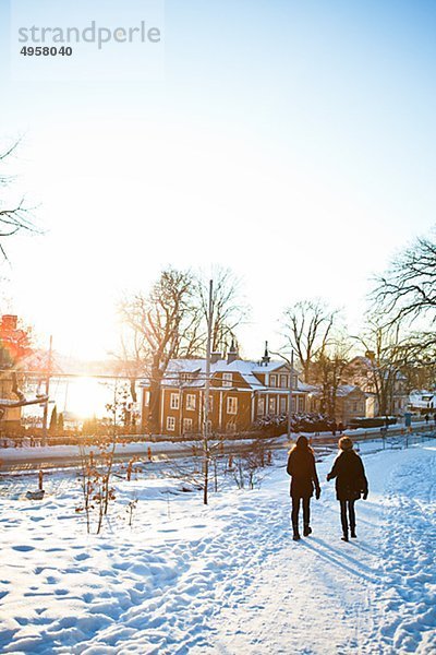 Zwei Frauen zu Fuß durch Schnee bedeckt Pfad