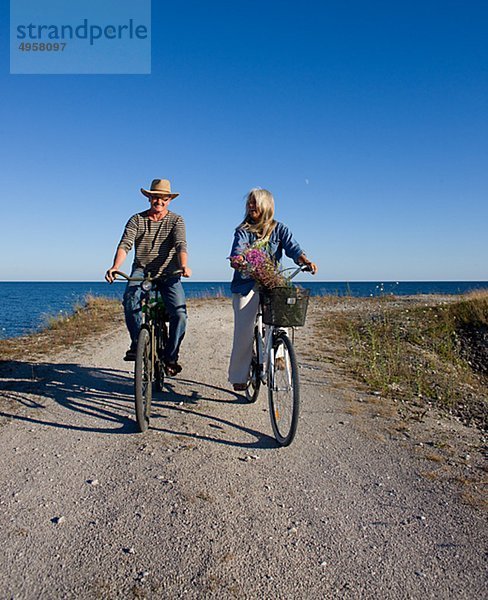 reifes Paar Fahrradfahren am Strand