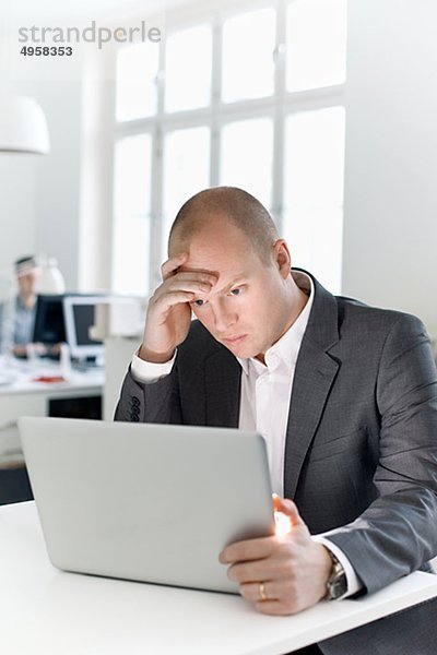 Mann sitzen in Büro Blick auf laptop