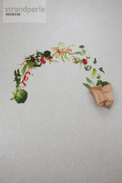 Gemüse aus der Papiertüte auf grauem Hintergrund