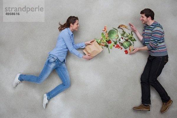 Mann und Frau balancieren Gemüse