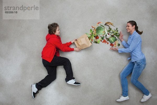 Frau und Junge balancieren Gemüse