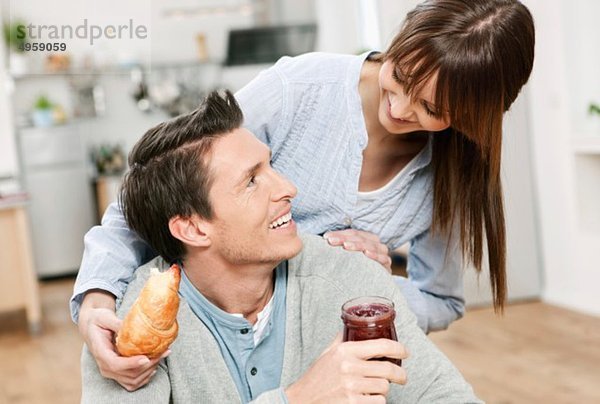 Mann und Frau in der Küche  Frau mit Croissant