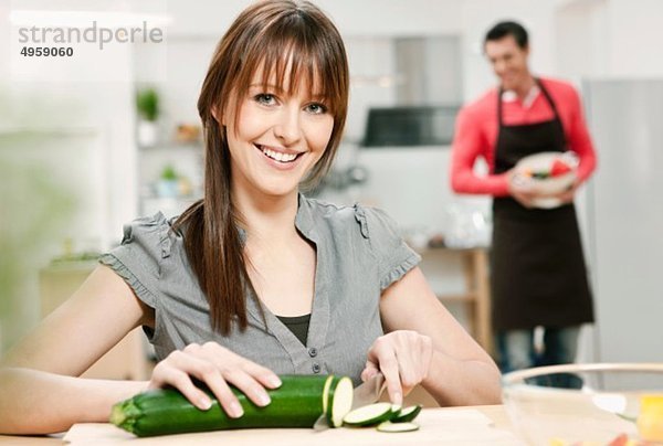 Frau beim Gurkenhacken in der Küche