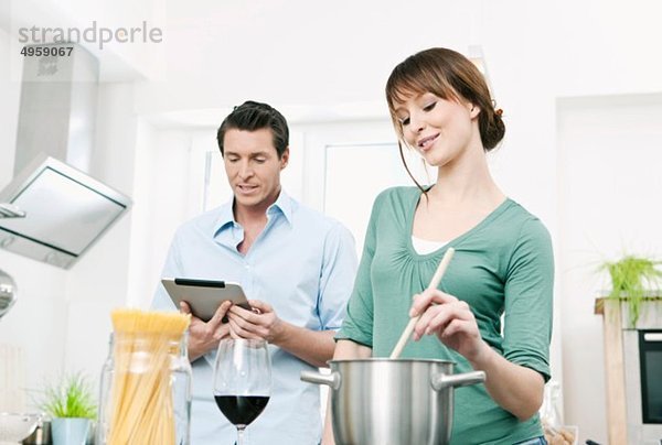 Mann und Frau bei der Zubereitung von Nudeln in der Küche