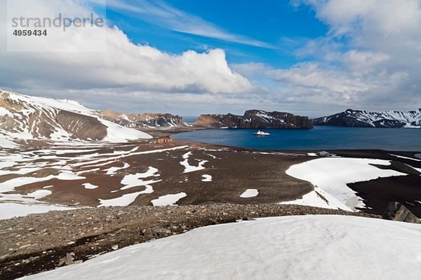 Südatlantik  Antarktis  Antarktische Halbinsel  Süd-Shetland  Deception Island  Whalers Bay  Deserted Hektor Walfangstation und Polarstern Eisbrecher Kreuzfahrtschiff in der Ferne.