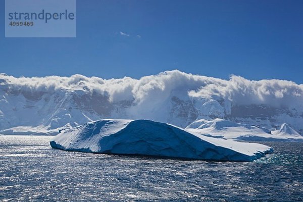 Südatlantik  Antarktis  Antarktische Halbinsel  Gerlache Straße  Blick auf den Eisberg mit schneebedecktem Gebirge