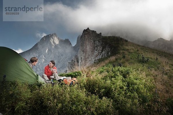 Österreich  Salzburger Land  Filzmoos  Paar sitzend neben Zelt auf Bergen