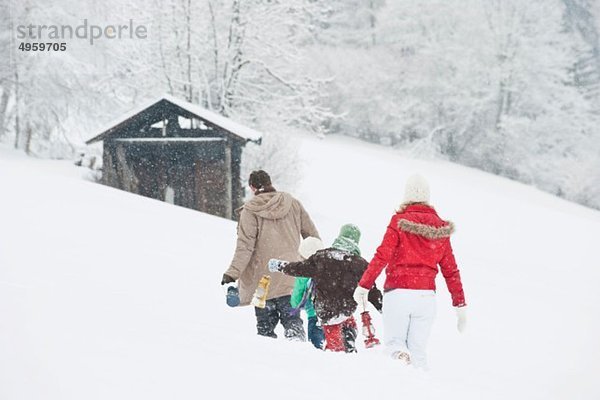 Österreich  Salzburg  Hüttau  Familie mit Laternenwanderung im Schnee