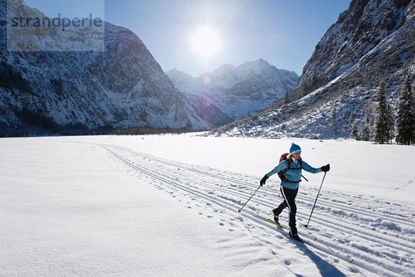 Seniorin beim Langlaufen mit Karwendalgebirge im Hintergrund