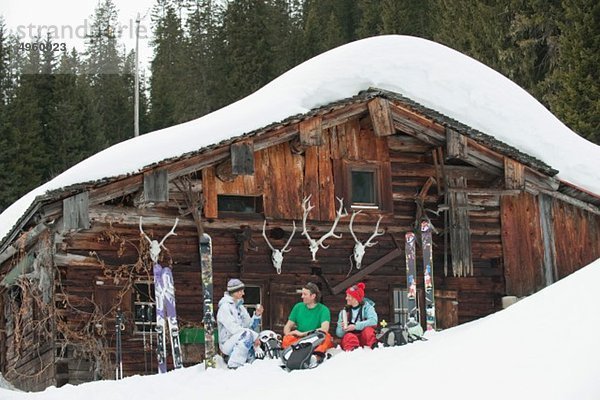 Österreich  Kleinwalsertal  Freunde sitzend bei der Berghütte