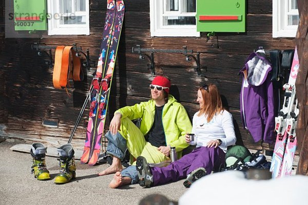 Österreich  Kleinwalsertal  Paar entspannen vor der Berghütte